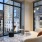 a room with a large window and a couch and a table with chairs
